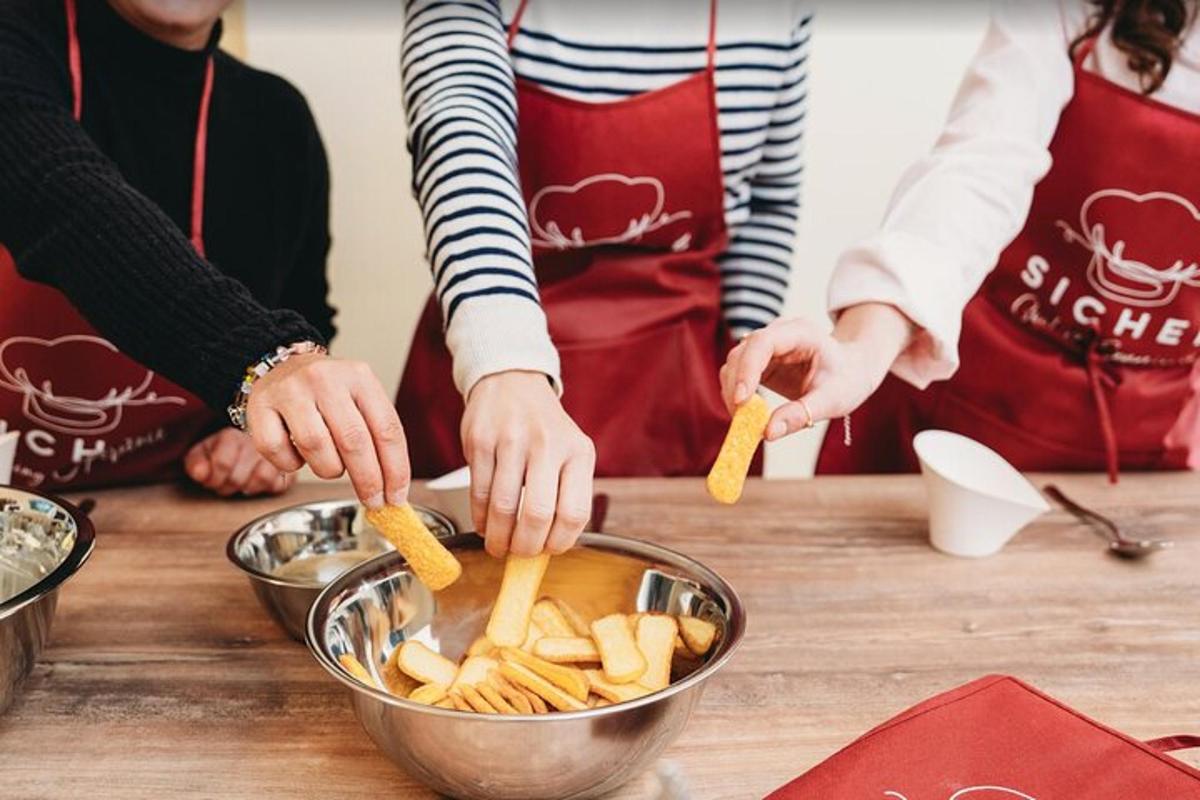 two people preparing food in a bowl on a table