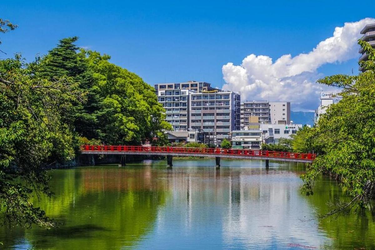 Un puente rojo sobre un río en una ciudad.