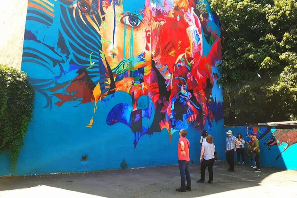 a group of people standing in front of a mural