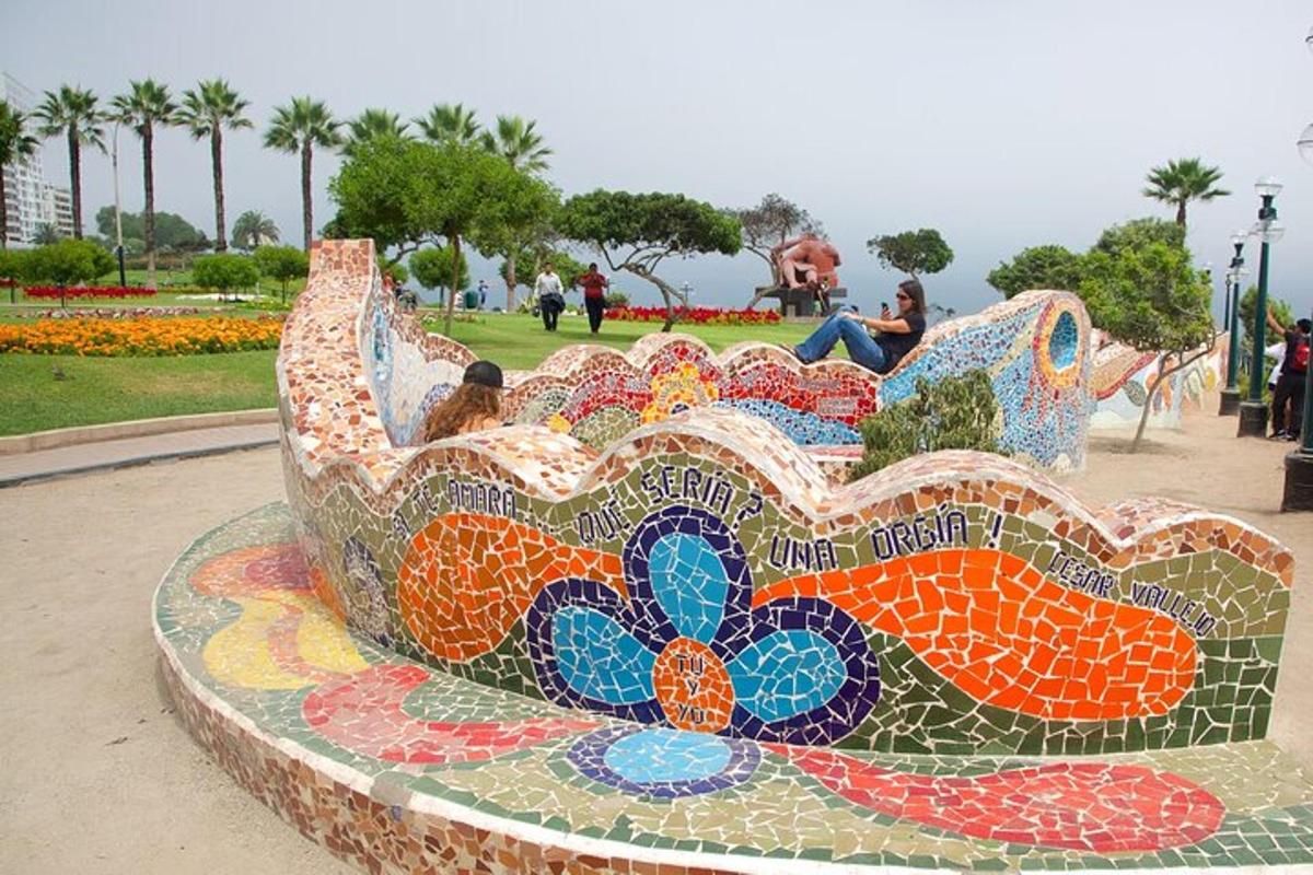 una panchina a mosaico in un parco con persone sedute su di essa