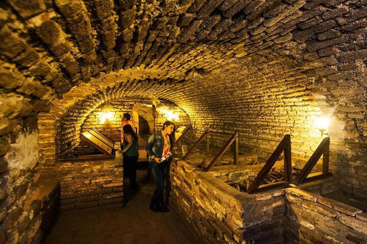 un gruppo di persone in piedi in un tunnel di mattoni
