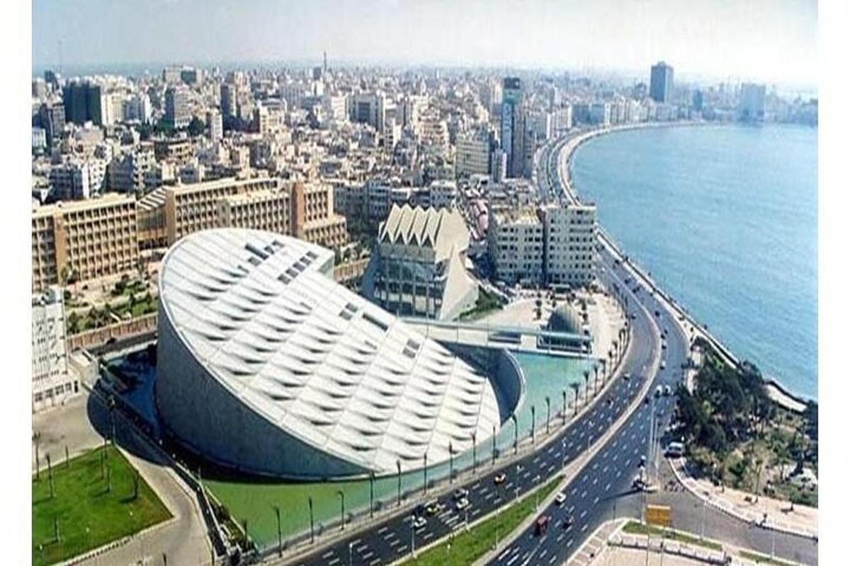 um grande edifício branco em uma cidade próxima ao oceano