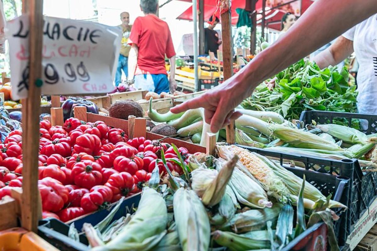 člověk sahající po zelenině na farmářském trhu