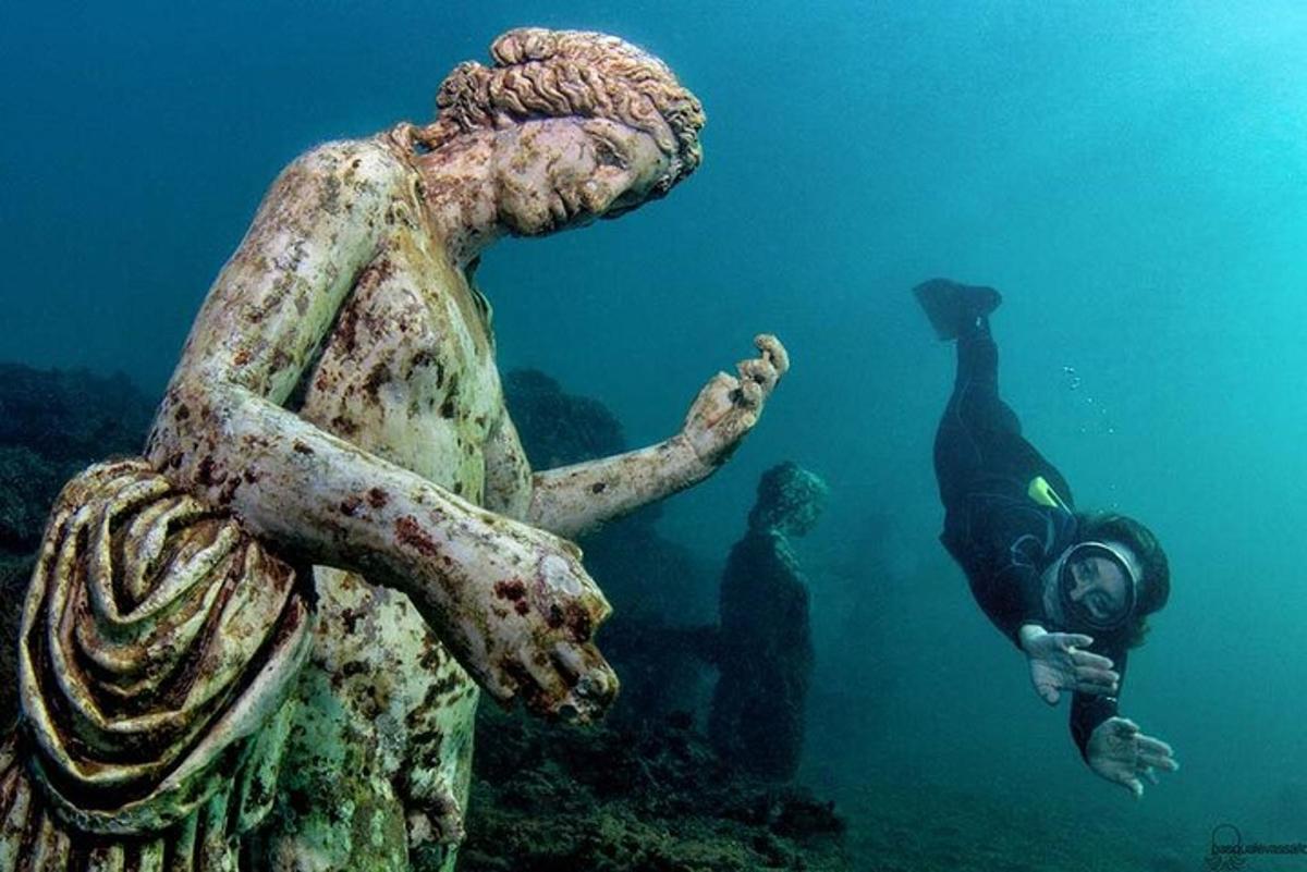Una estatua de una mujer con un buceador en el agua.