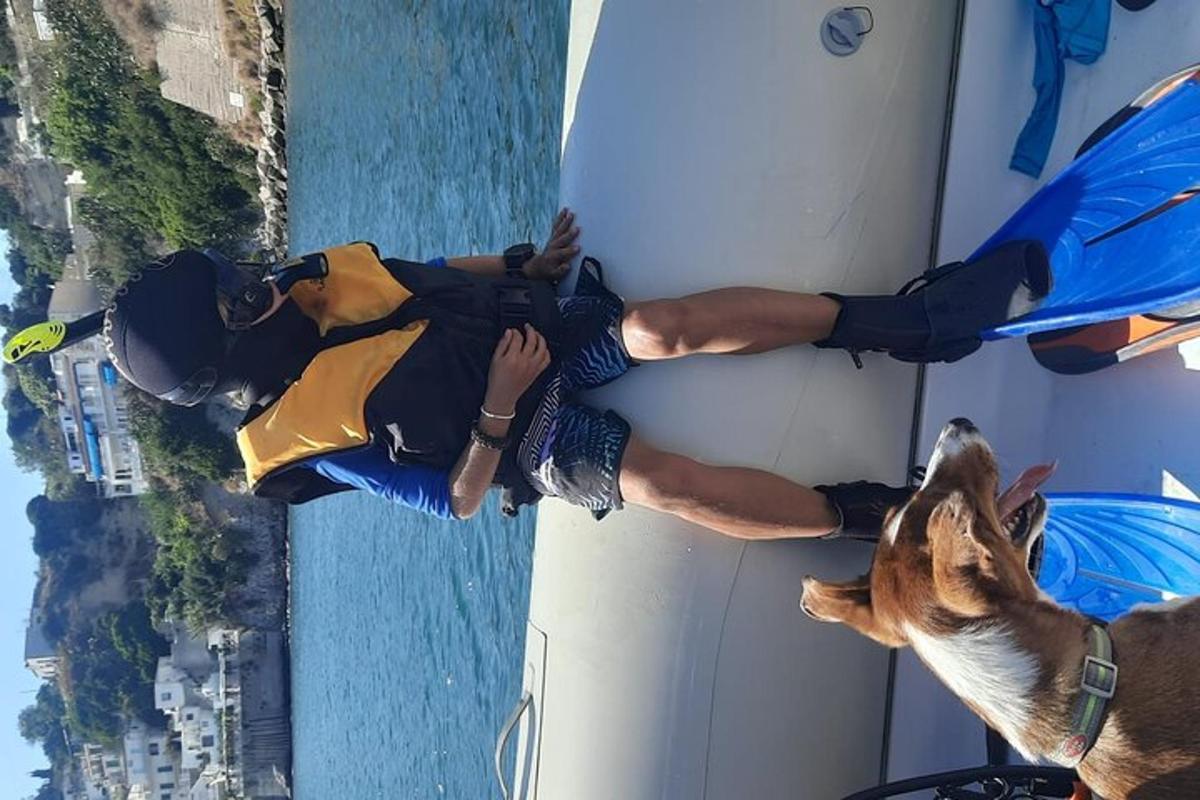 Un hombre y un perro de pie junto a una tabla de surf.