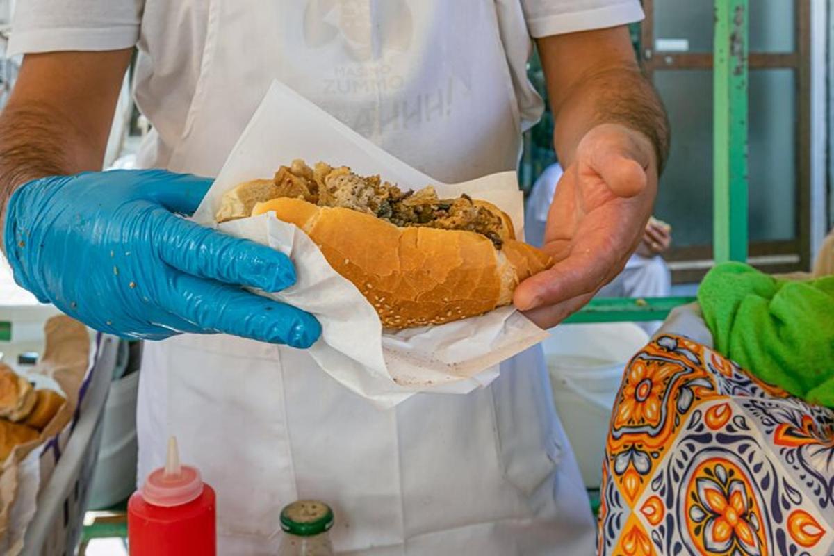 un uomo tiene un panino tra le mani