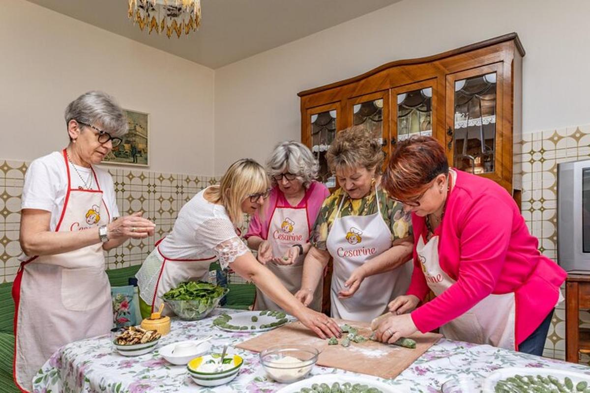 un gruppo di donne in piedi attorno a un tavolo che preparano il cibo