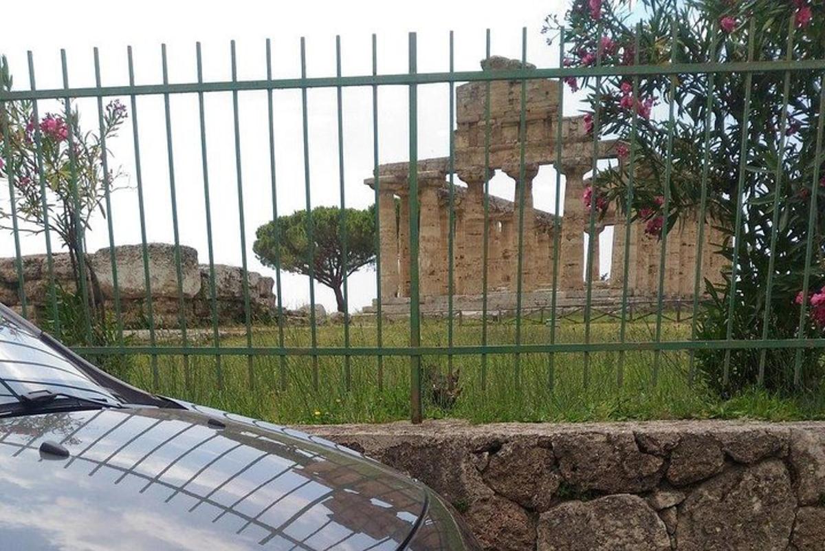 o mașină parcată în fața unui gard din fața unei clădiri