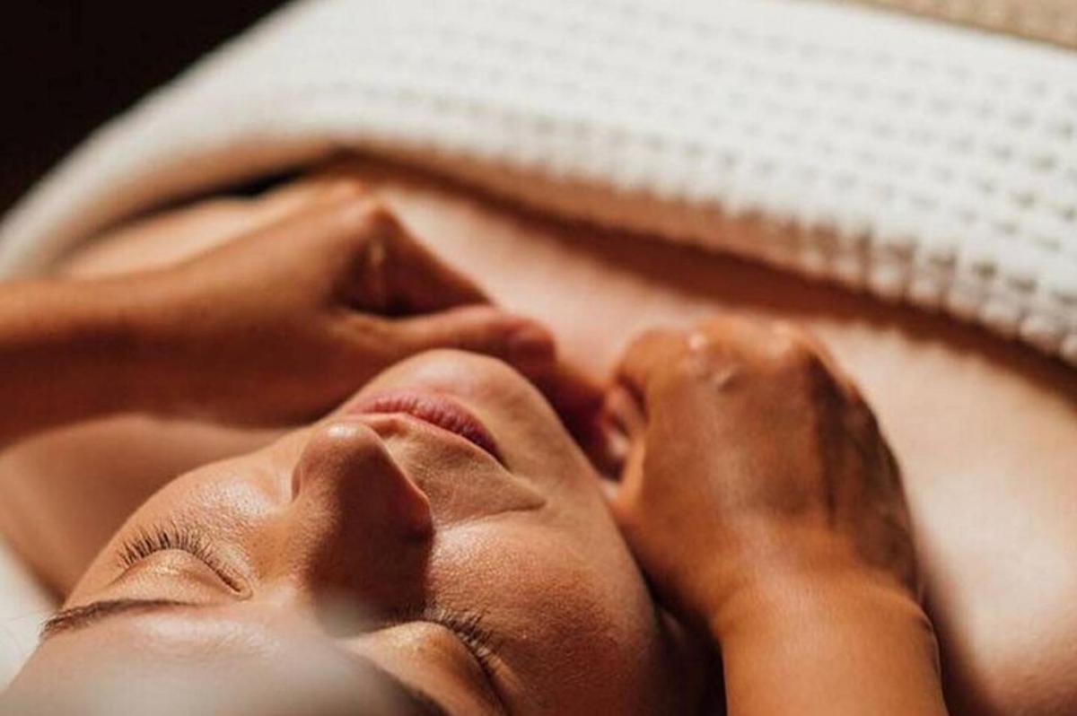 a woman laying on a bed with her eyes closed