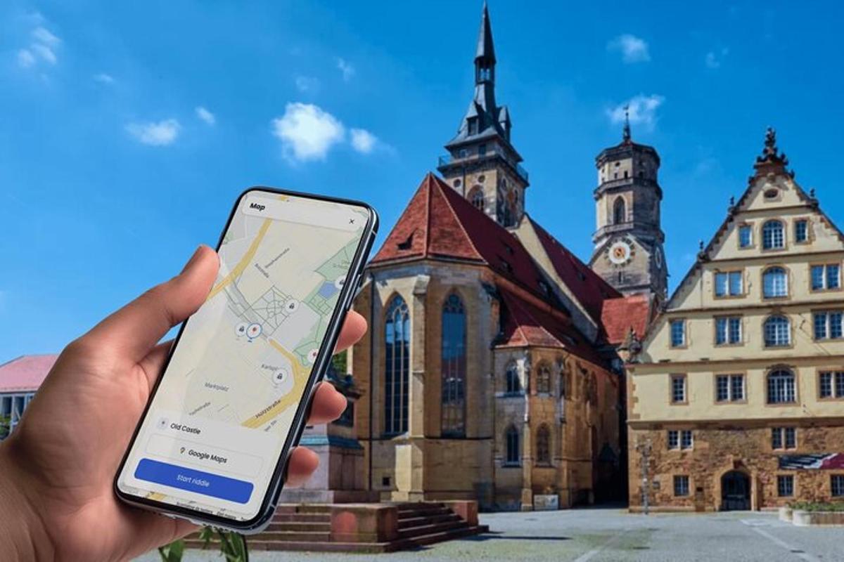 osoba držící mobilní telefon před budovou