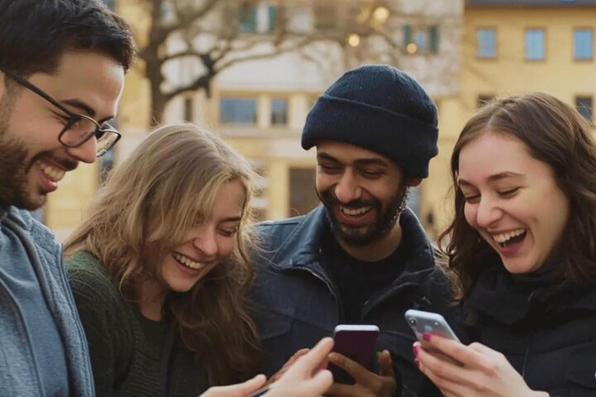 a group of people looking at their cell phones