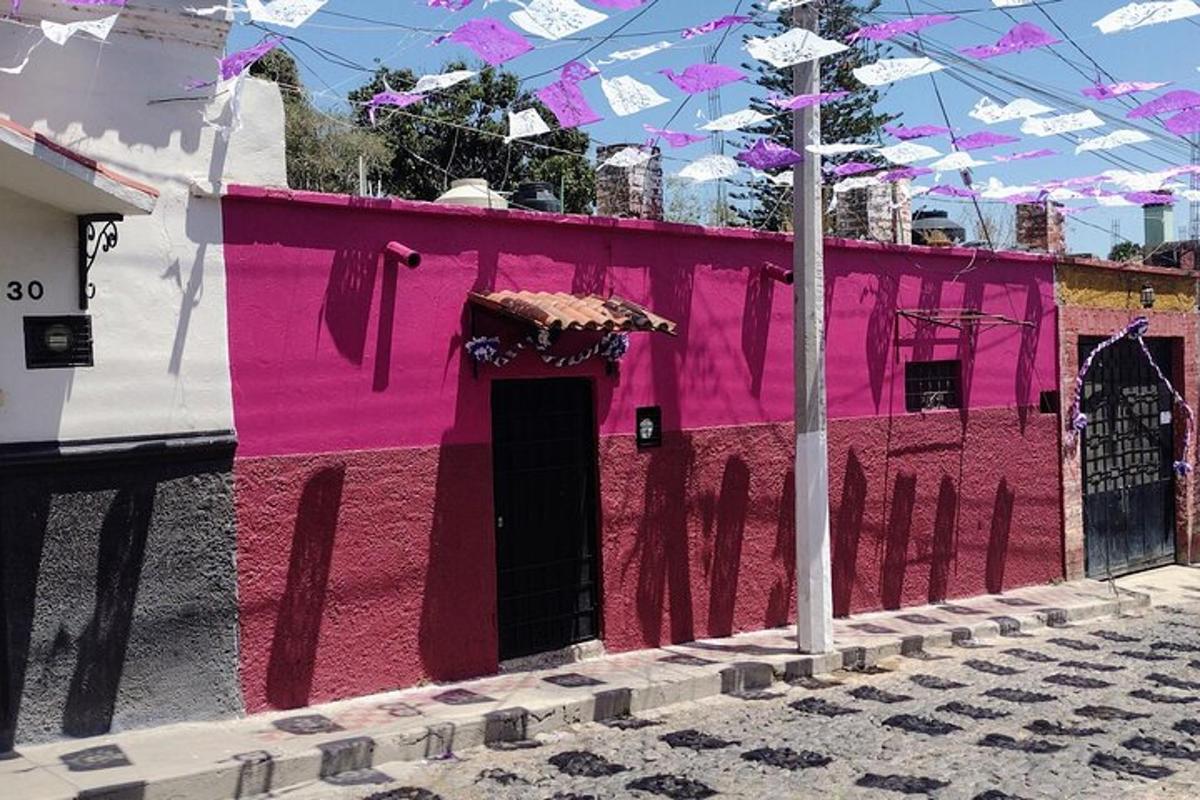 a pink building with a black door on a street