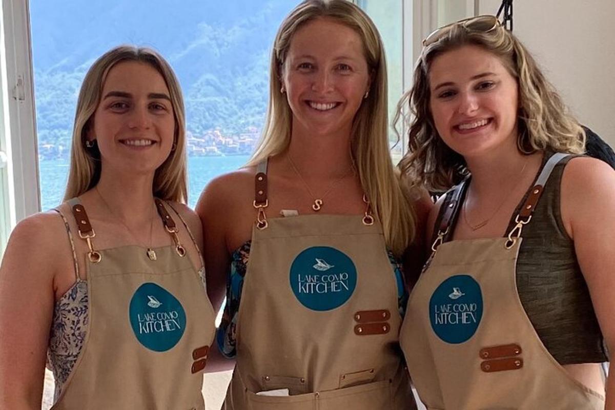 Dos mujeres con delantales con el nuevo logotipo de la cocina.