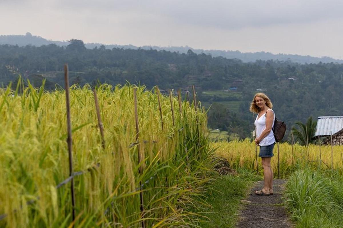isang babaeng nakatayo sa isang maruming kalsada sa isang bukid