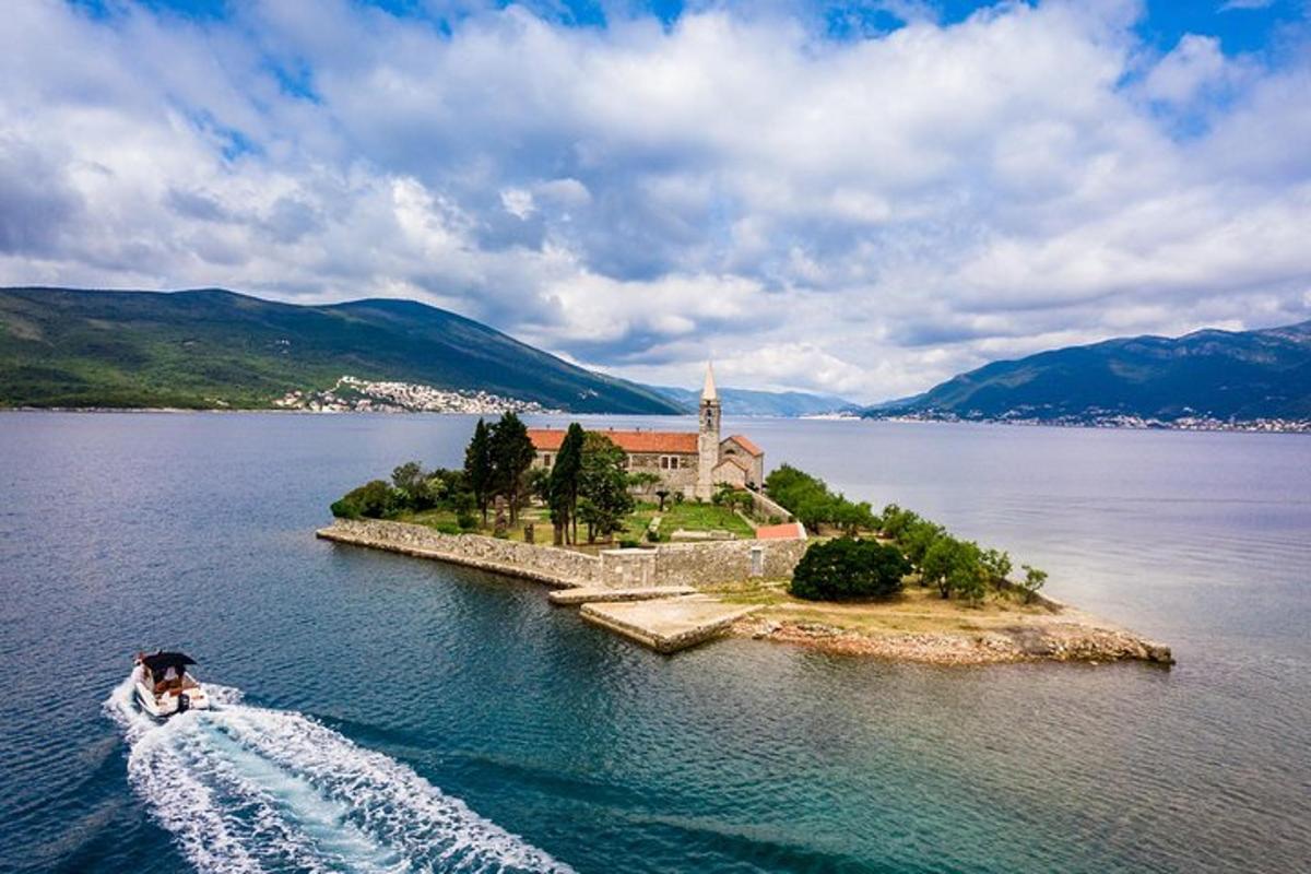 μια βάρκα σε ένα υδάτινο σώμα με μια εκκλησία σε ένα νησί