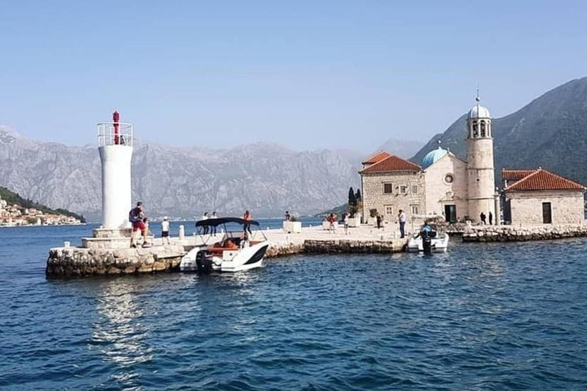 a small boat on the water next to a lighthouse