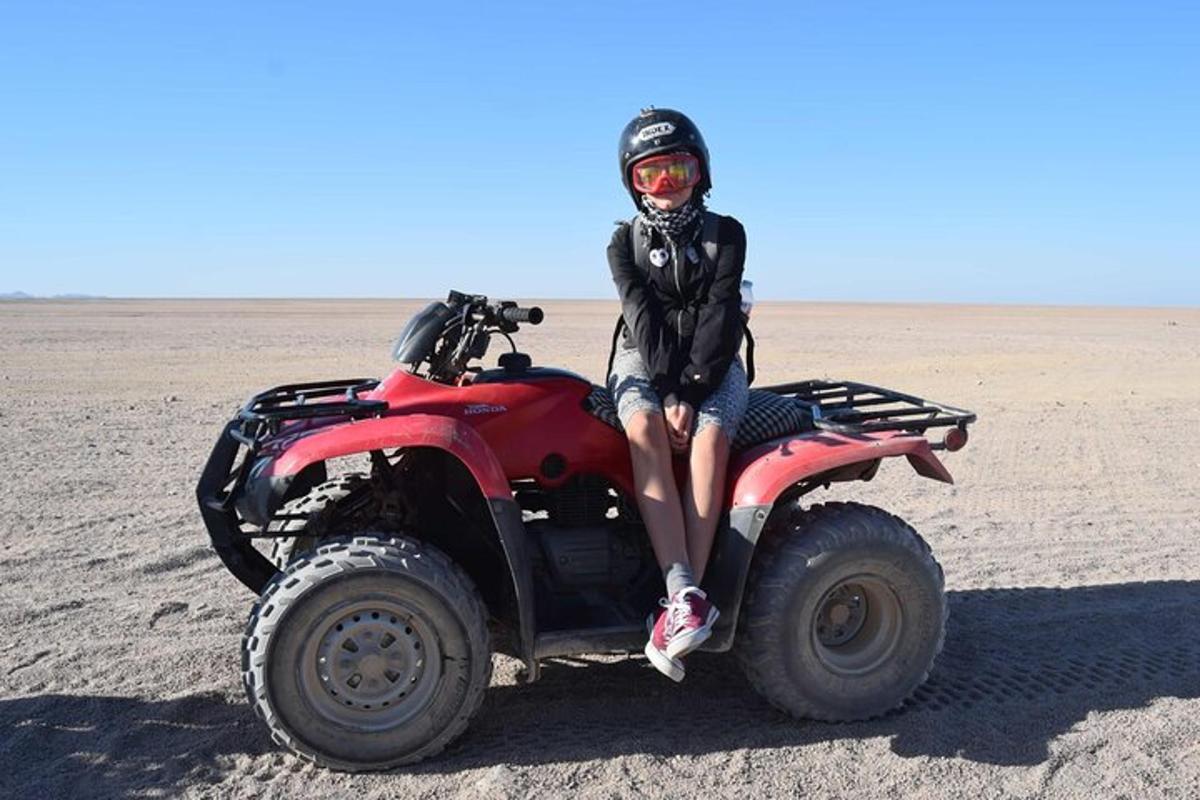 una persona seduta su un quad nel deserto