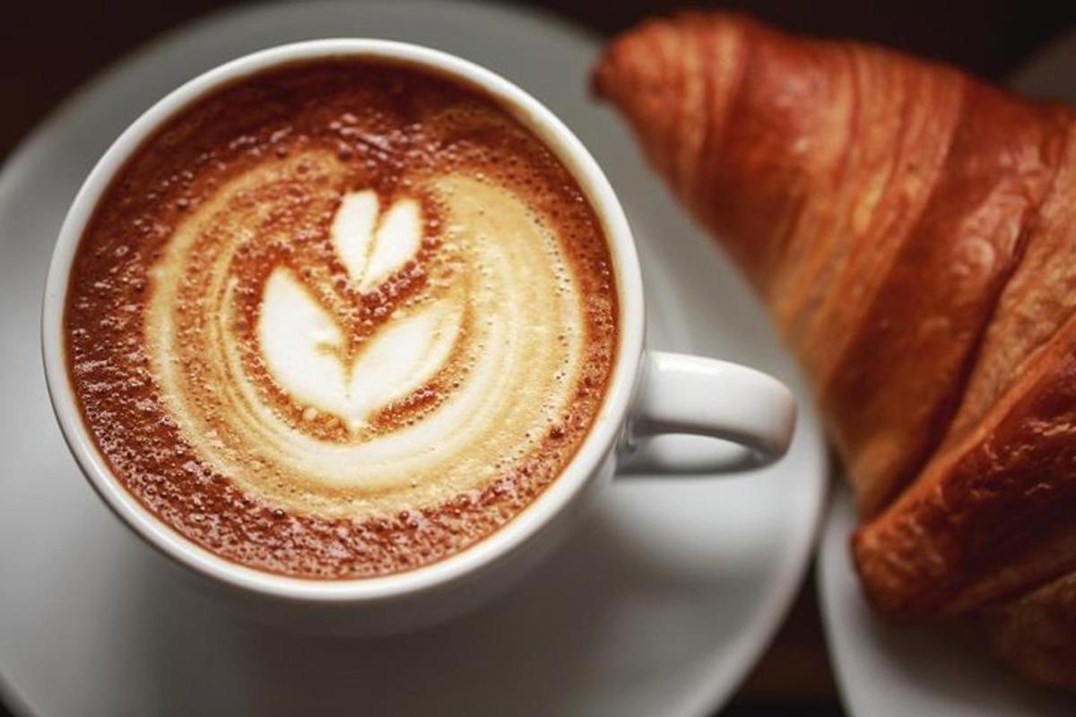 secawan kopi di atas pinggan dengan croissant