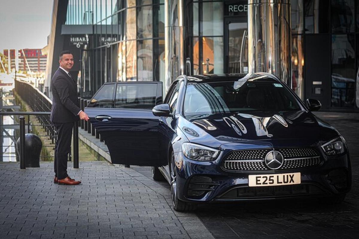 a man in a suit standing next to a car