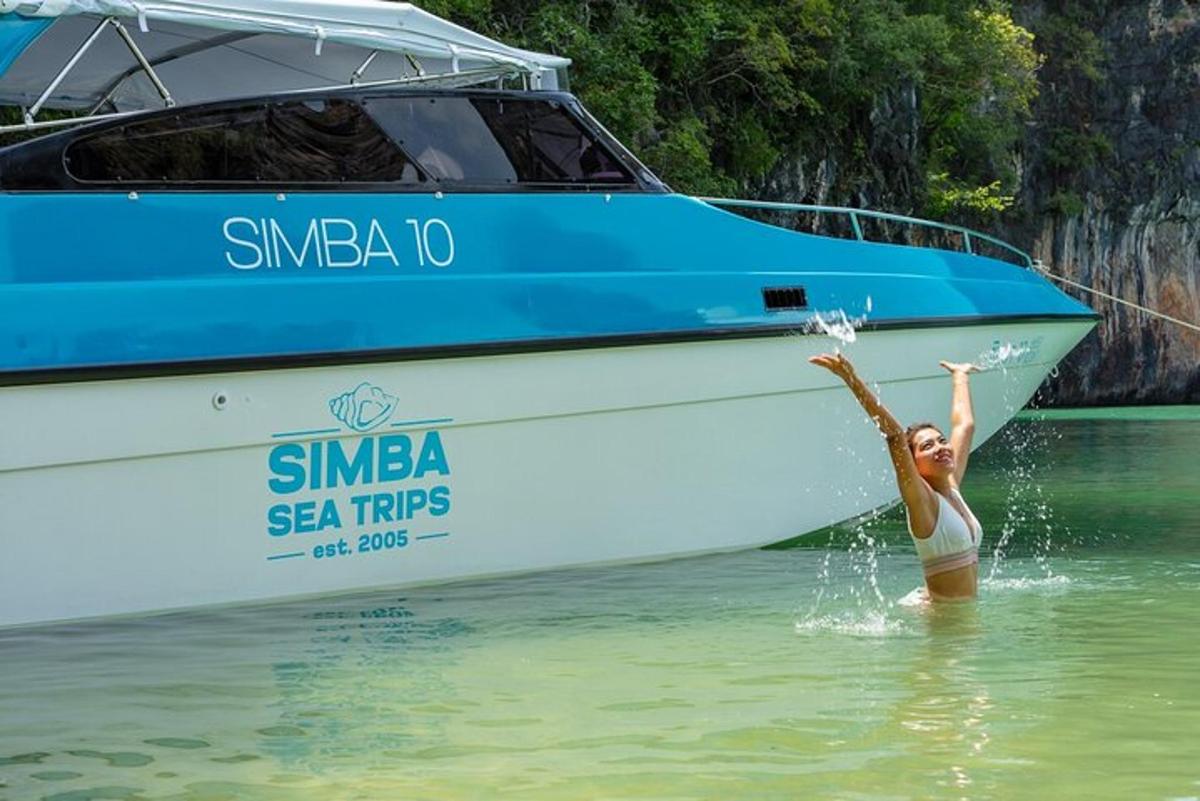 a woman standing in the water next to a boat