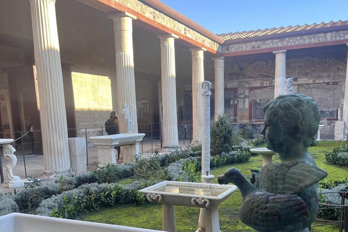 ένα άγαλμα μιας γυναίκας που ταΐζει δύο πάπιες σε ένα σιντριβάνι