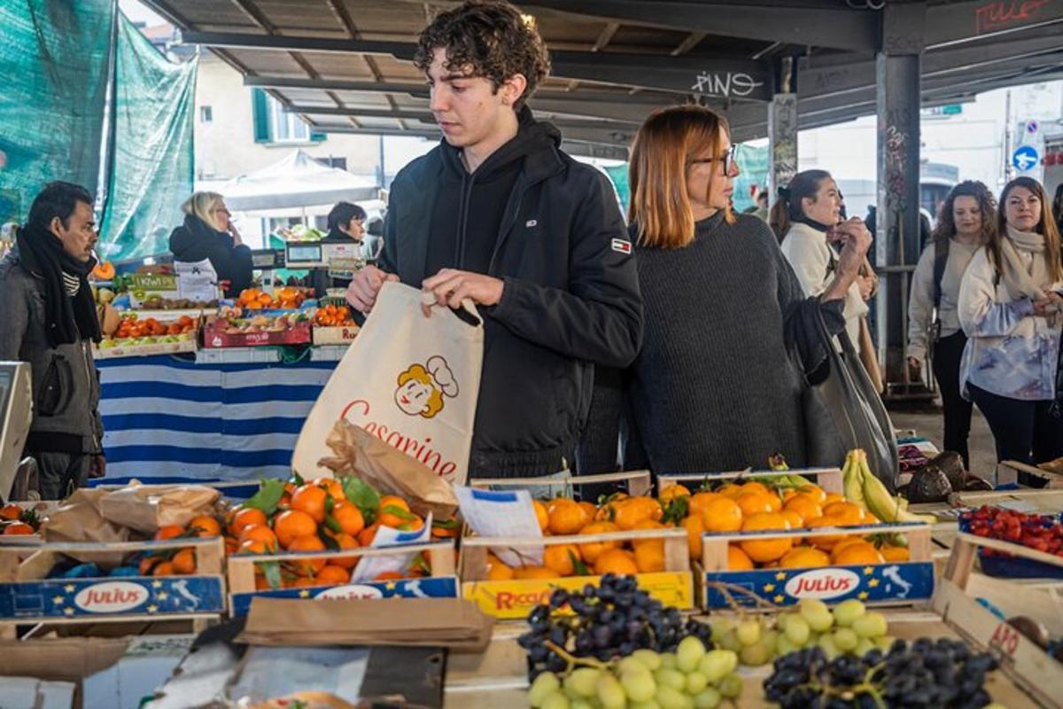 mees, kes hoiab puuviljaturul kotti
