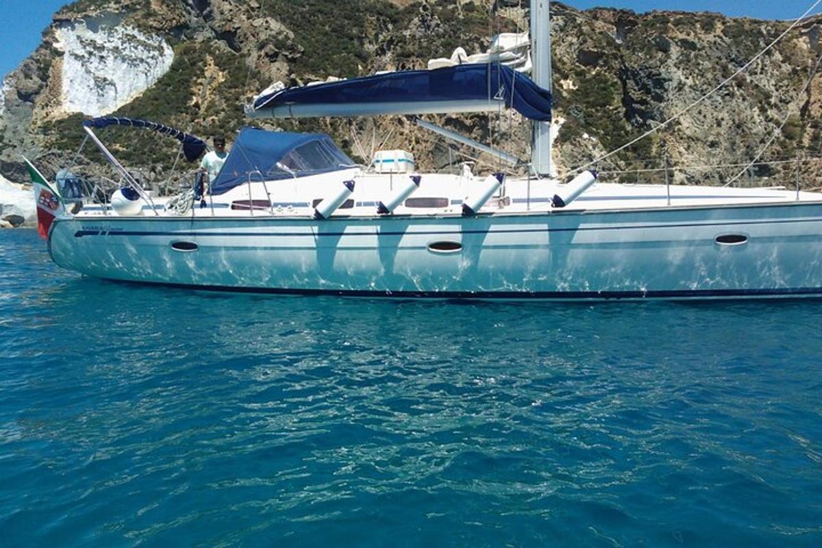 ein blaues Boot, das im Wasser in der Nähe einer Klippe liegt