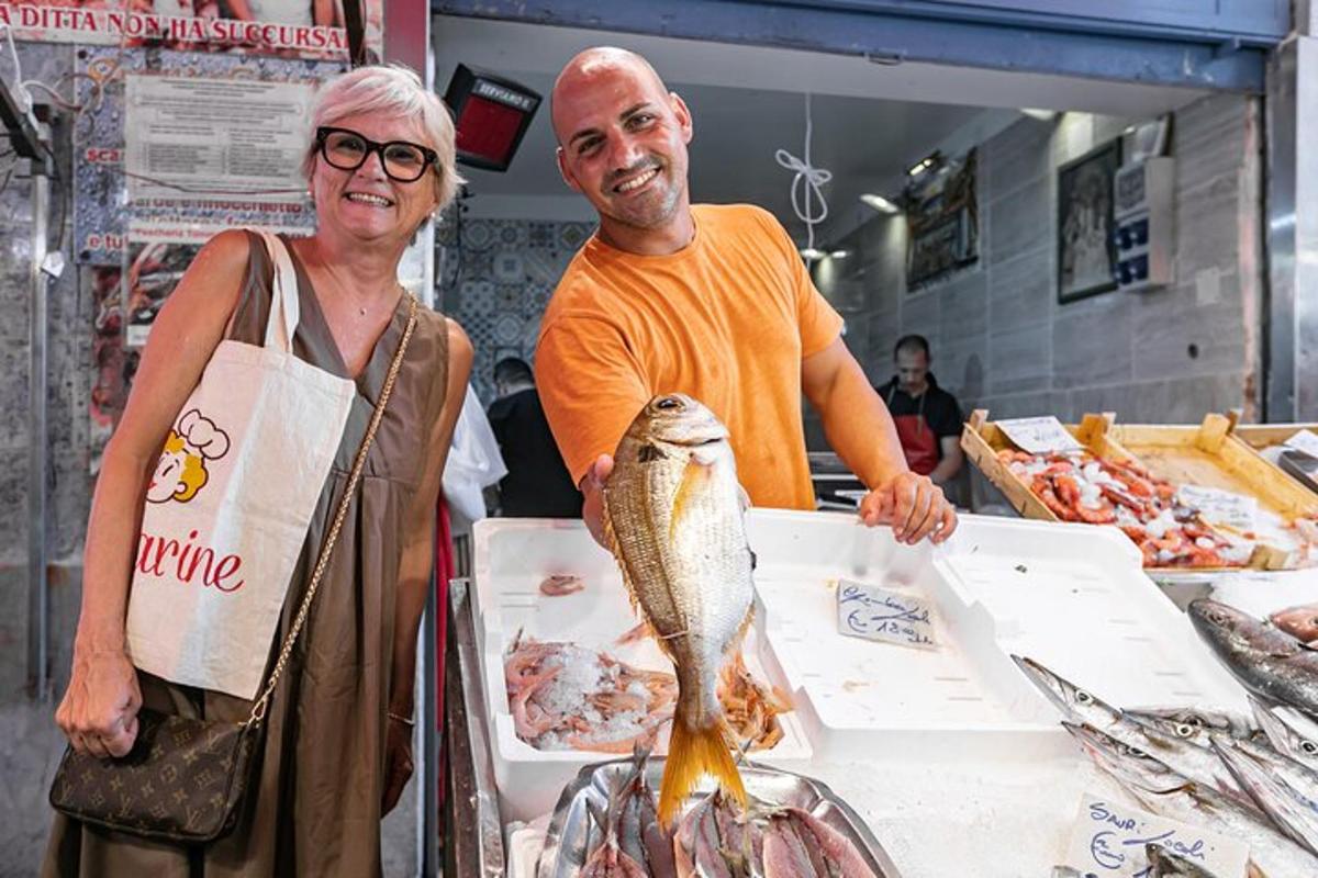 un uomo e una donna in piedi dietro un bancone con un pesce