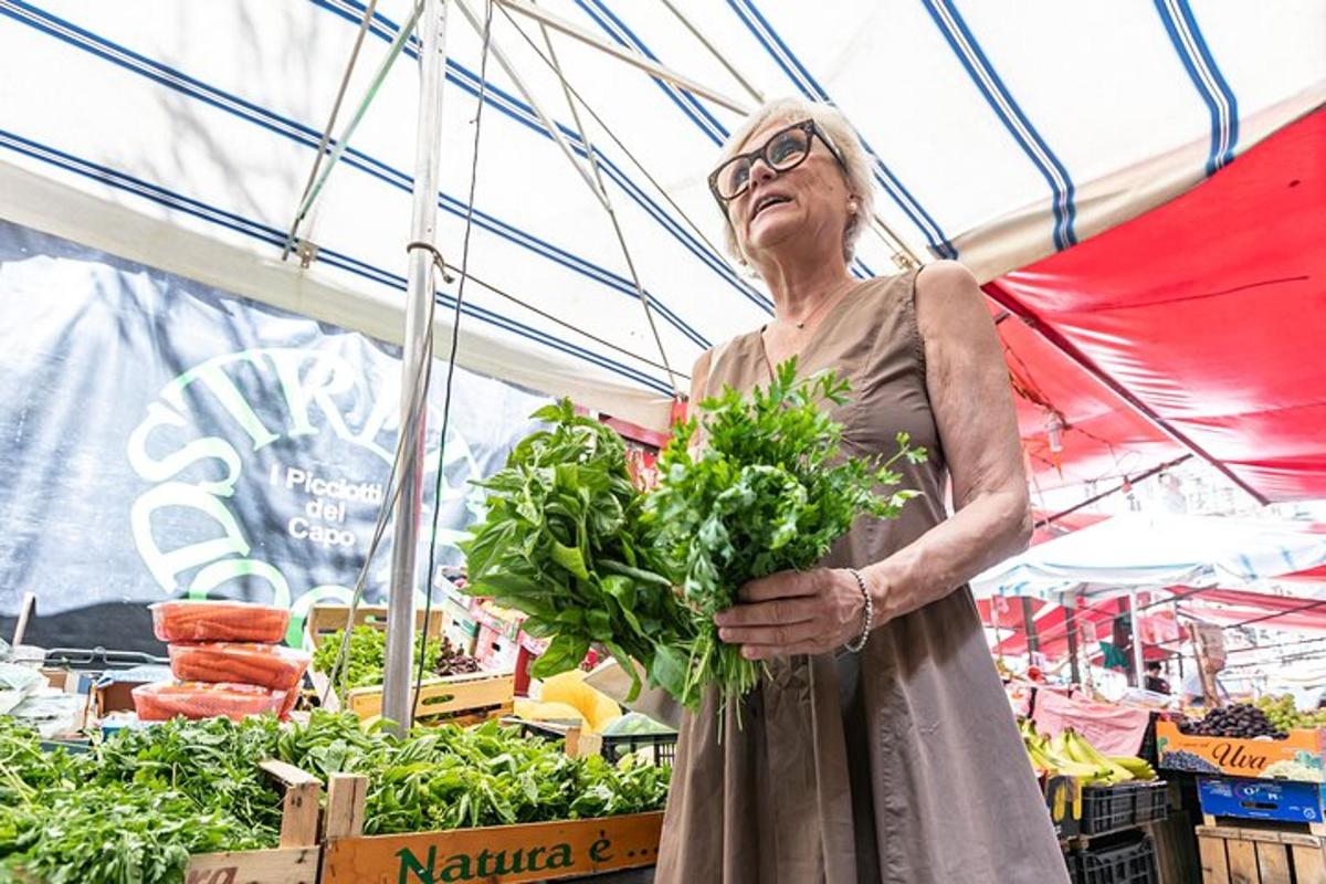 Una mujer mayor sosteniendo un manojo de verduras en un mercado
