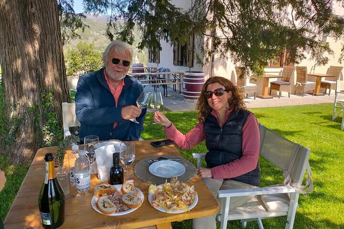 Un hombre y una mujer sentados en una mesa con copas de vino.