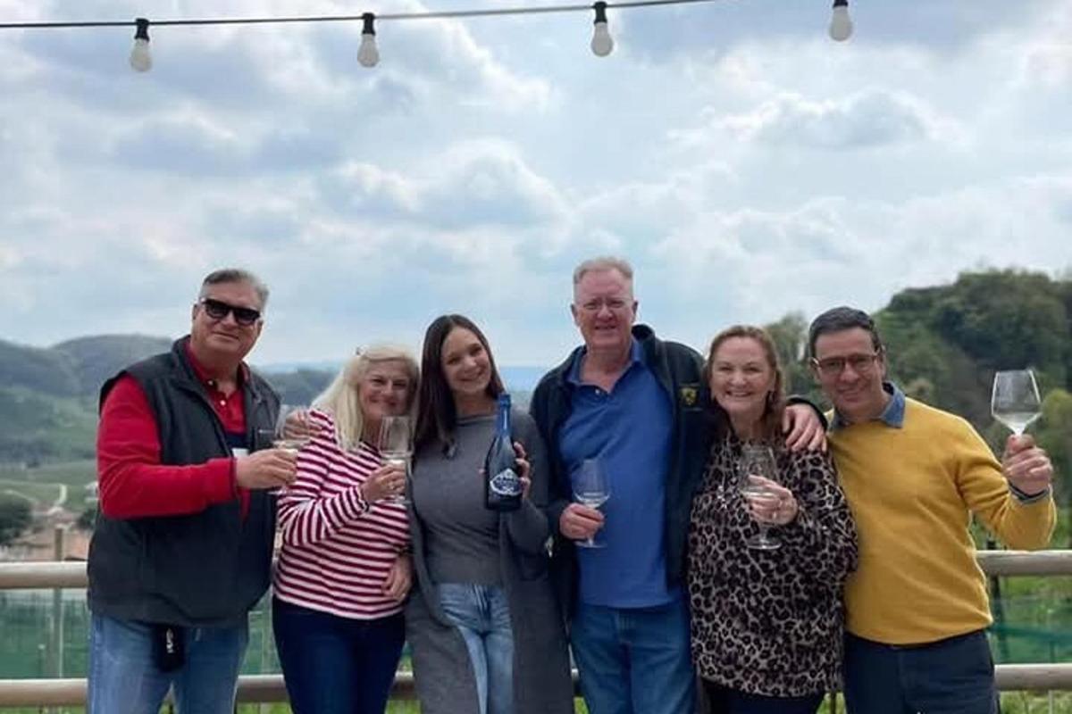 un grup de persones posant per a una foto amb copes de vi