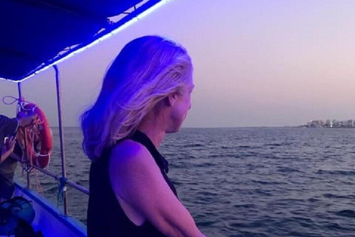 a woman with purple hair on a boat in the water