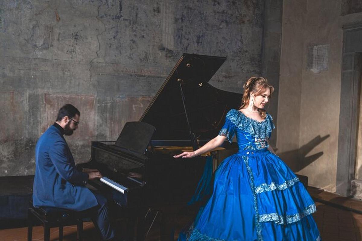 una dona amb un vestit blau dempeus davant d'un piano