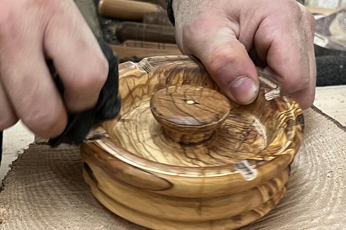 seseorang memotong mangkuk kayu dengan sepasang gunting