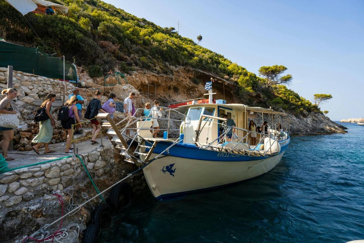 un gruppo di persone che salgono su una barca in acqua