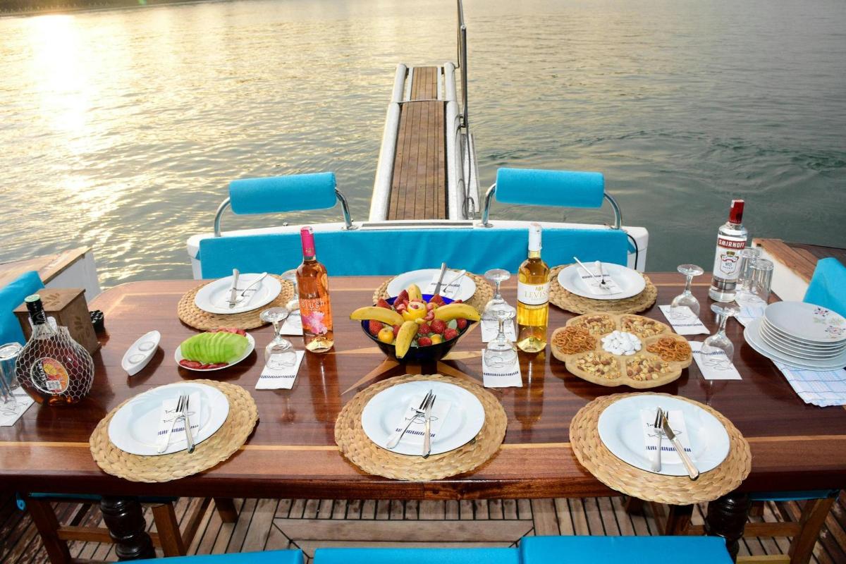 ein Holztisch mit Tellern voller Essen auf einem Boot