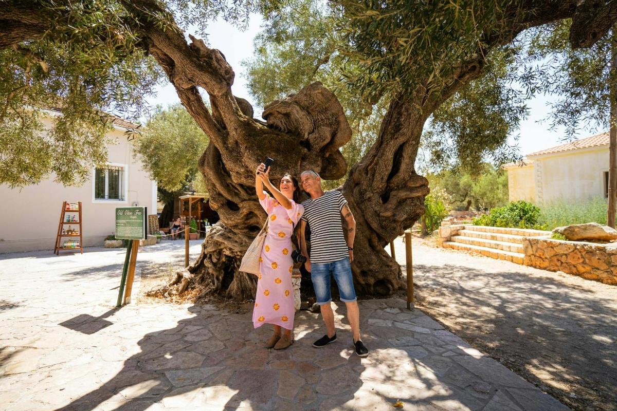 ένας άντρας και μια γυναίκα που στέκονται δίπλα σε ένα δέντρο