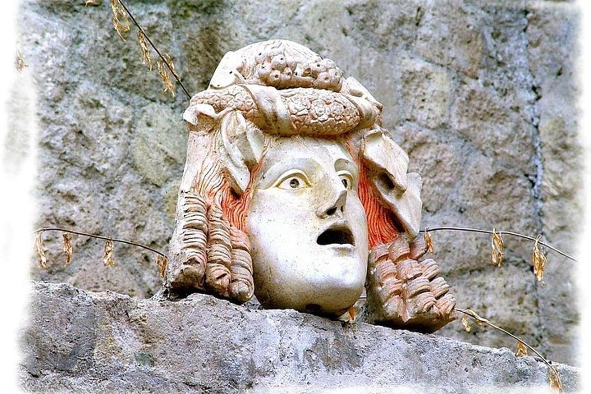 una statua di una testa su un muro di pietra