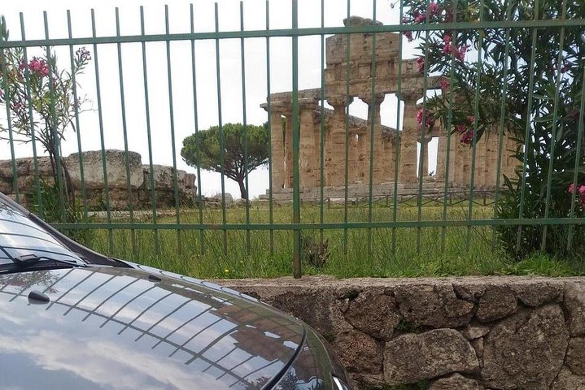 un cotxe aparcat davant d'una tanca amb un edifici