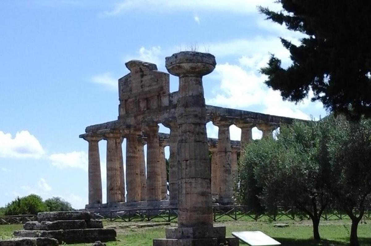an ancient building with a pillar in a field