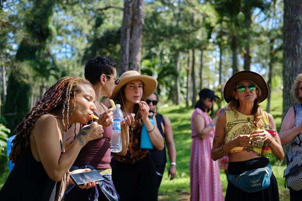 un gruppo di persone in piedi in un parco che mangiano cibo