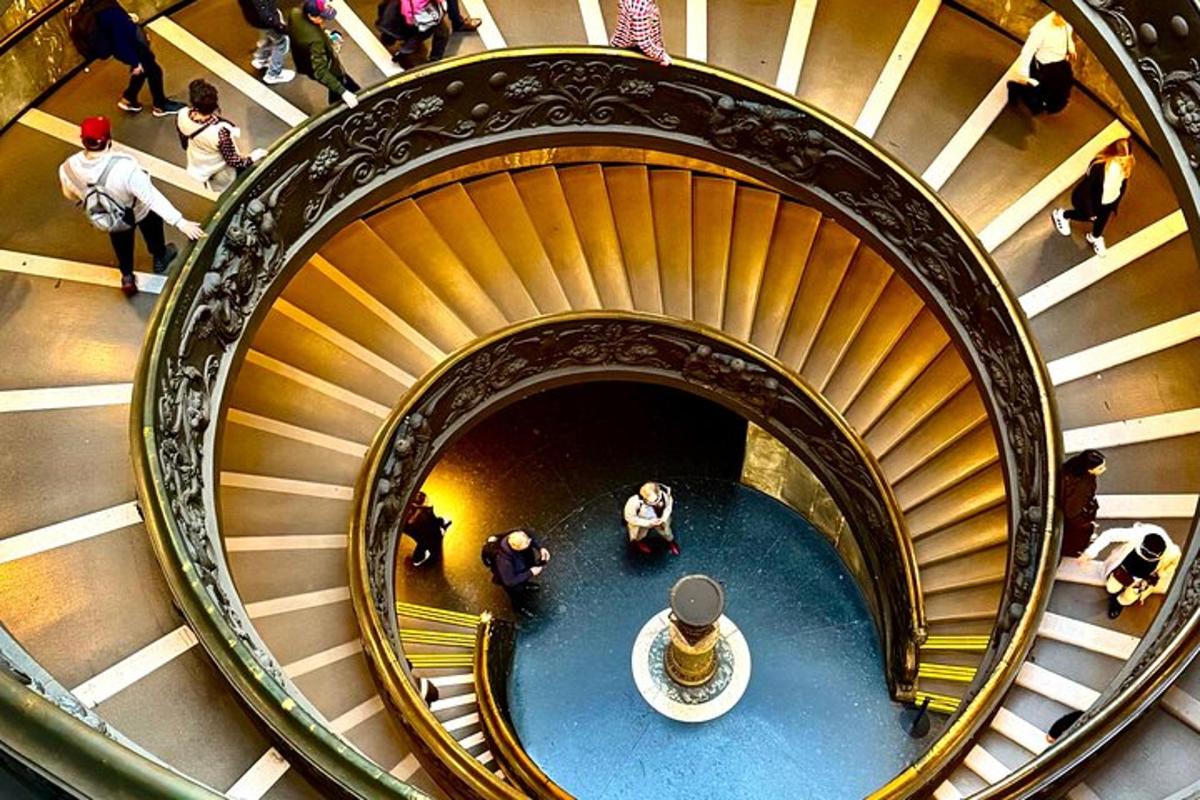 uma escada em espiral em um prédio com pessoas descendo por ela