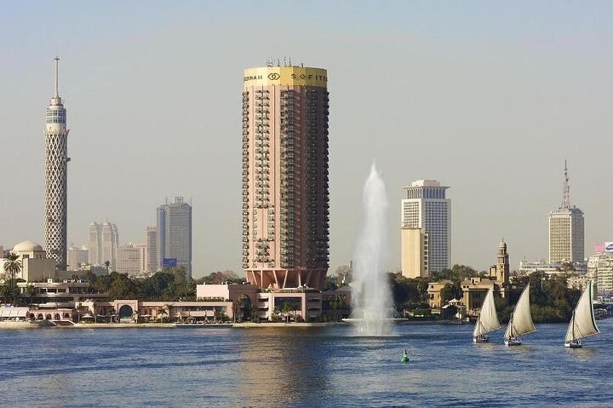 a group of sailboats in the water in front of a city
