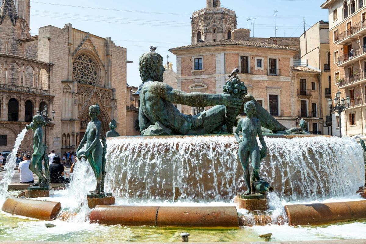 a fountain with statues in front of a building
