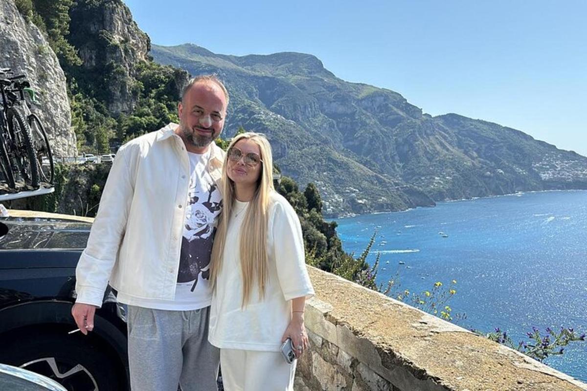 muž a žena stojící na zdi u vody