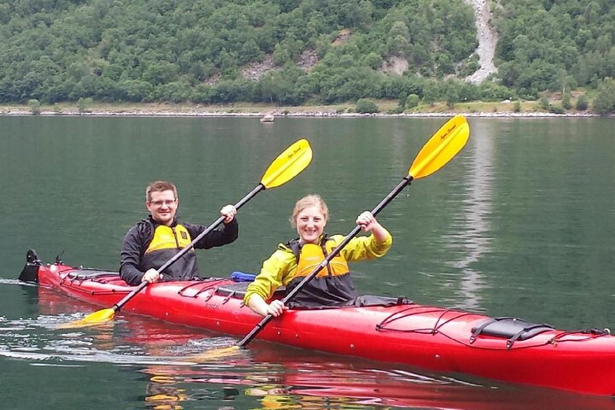 a man and woman in a red kayak on a lake
