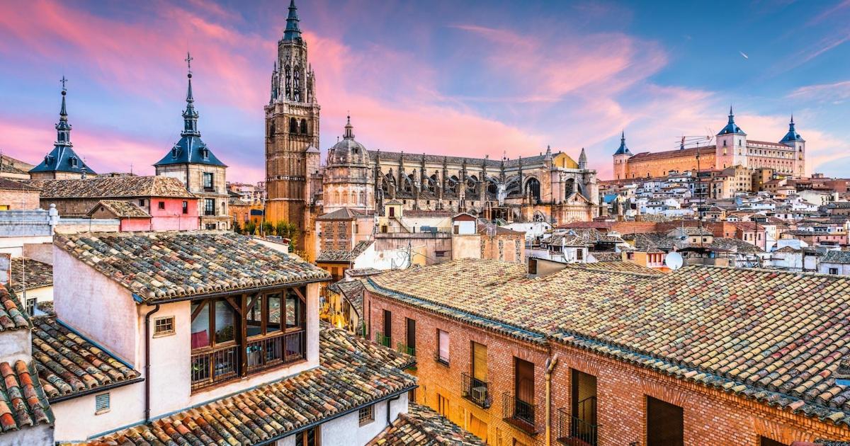 a cityscape of a city with roofs and a clock tower