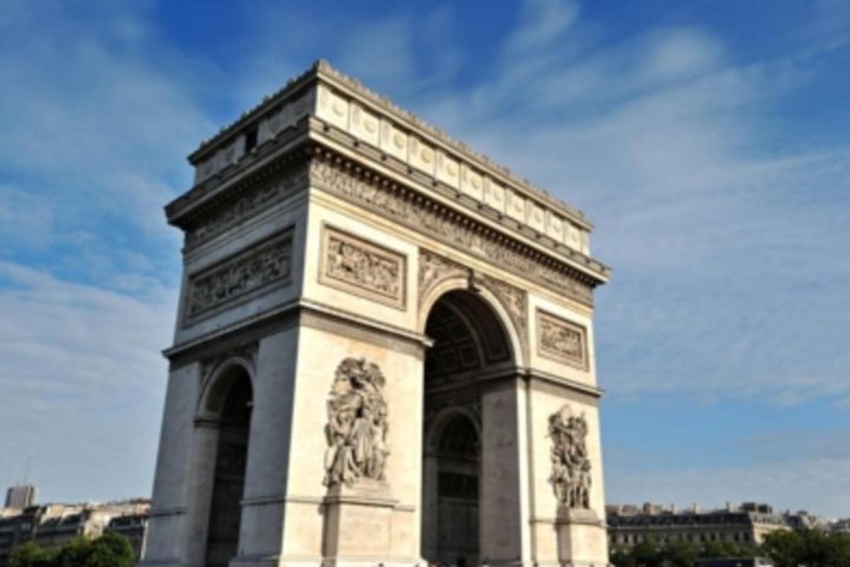 a large building with an arch with statues on it