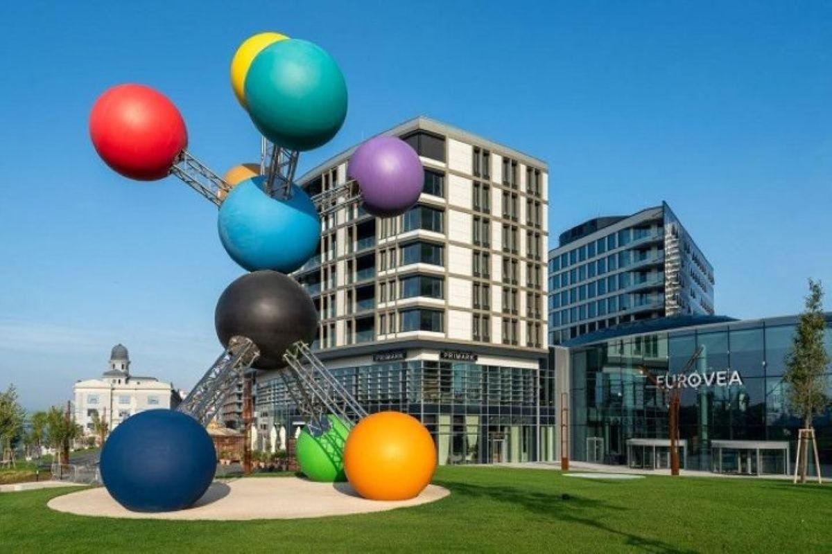 a statue with balloons in front of a building