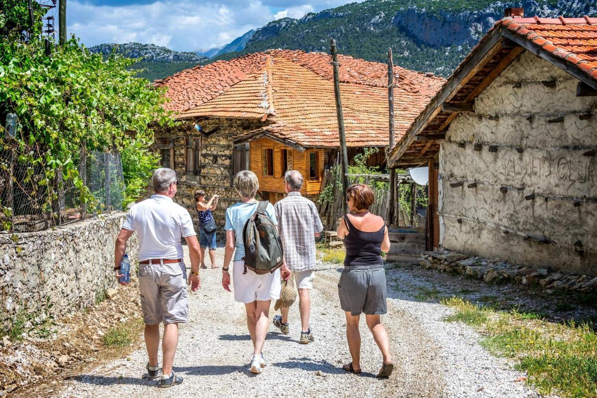 un grup de oameni care merg prin fața unei case